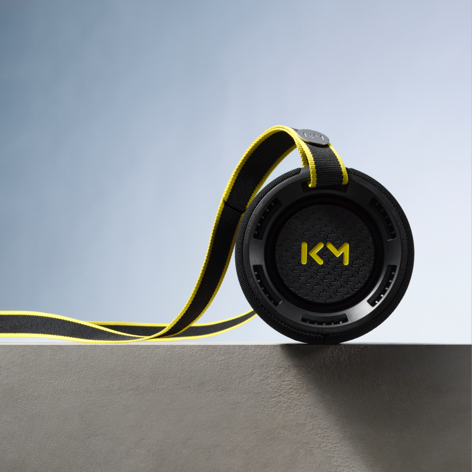 We. HEAR Pro Black – tragbarer Bluetooth-Lautsprecher liegend auf Betonblock