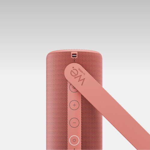 We. HEAR 1 coral red – aufgestellt in Seitenansicht mit sichtbaren Bedientasten des tragbaren 40-Watt Bluetooth-Lautsprechers